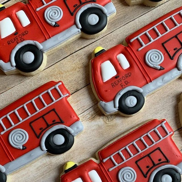 cookies decorated like firetrucks on a wooden table