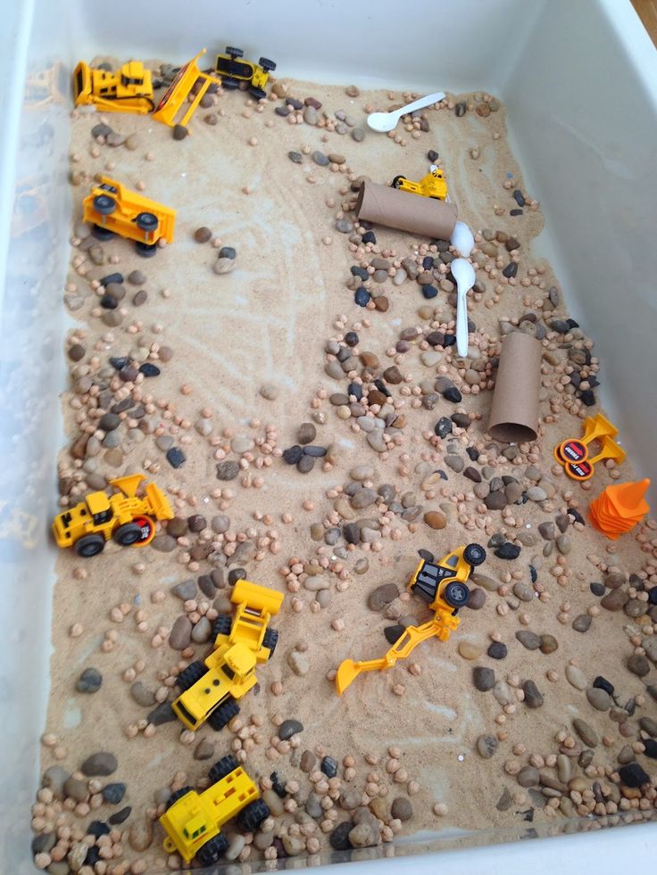 there are construction vehicles in the sand and rocks on the ground with plastic cups next to them