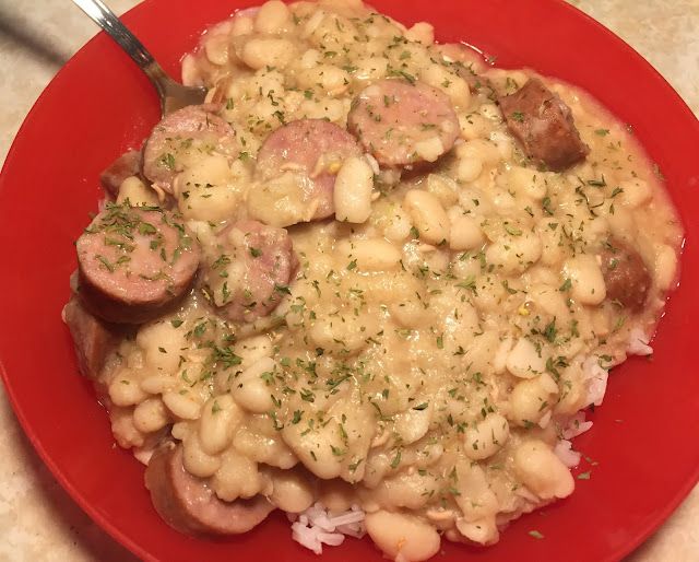 a red plate topped with beans and sausage