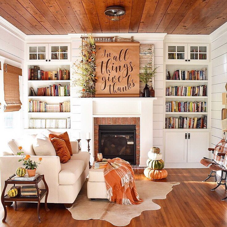 a living room filled with furniture and a fire place in front of a book shelf