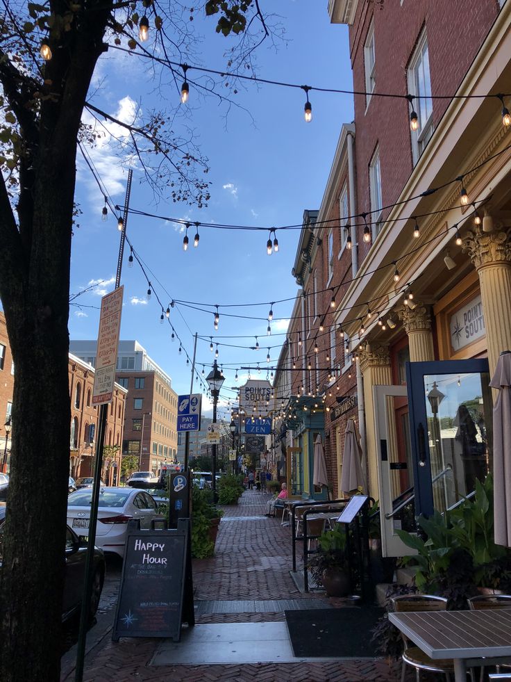 an empty street with lights strung from the buildings