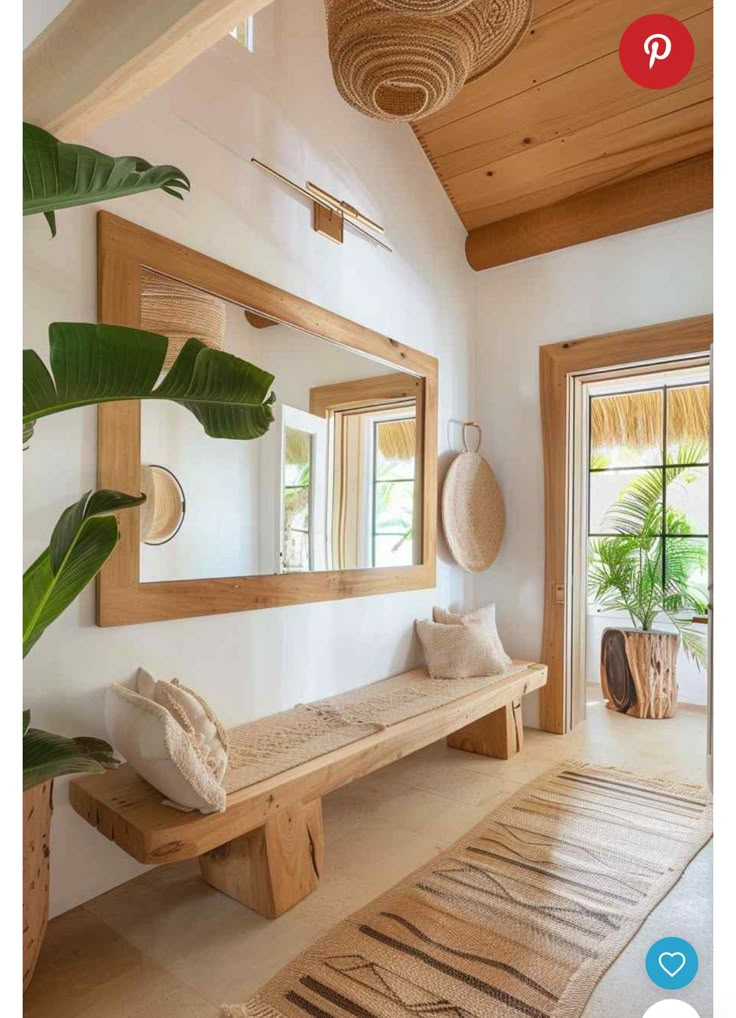 a wooden bench sitting under a mirror in a living room next to a potted plant