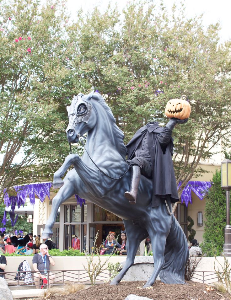 a statue of a man riding a horse with a pumpkin on it's head