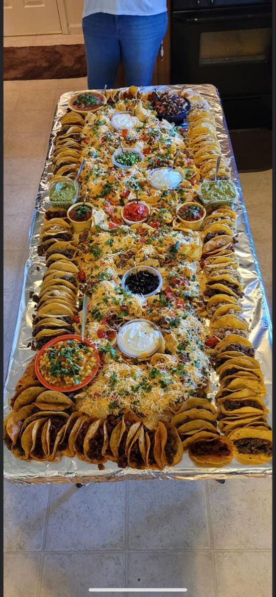 a woman standing in front of a table full of food