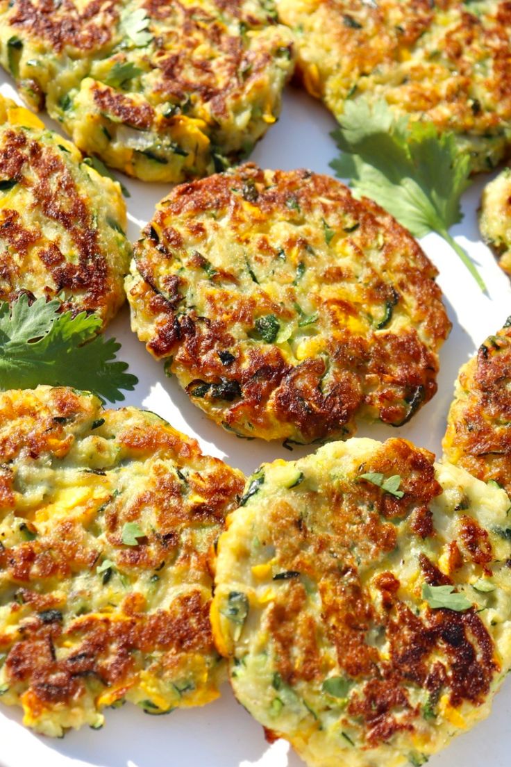 several crab cakes on a white plate with parsley