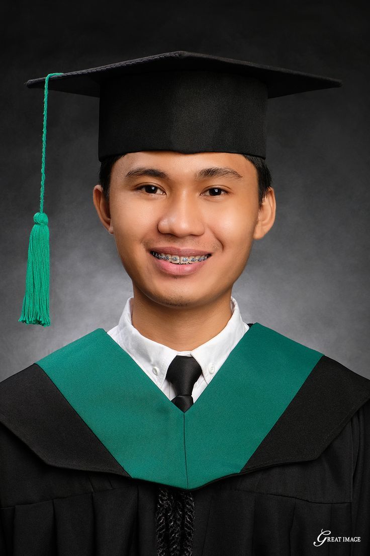 a young man wearing a graduation gown and smiling at the camera with his cap and gown on