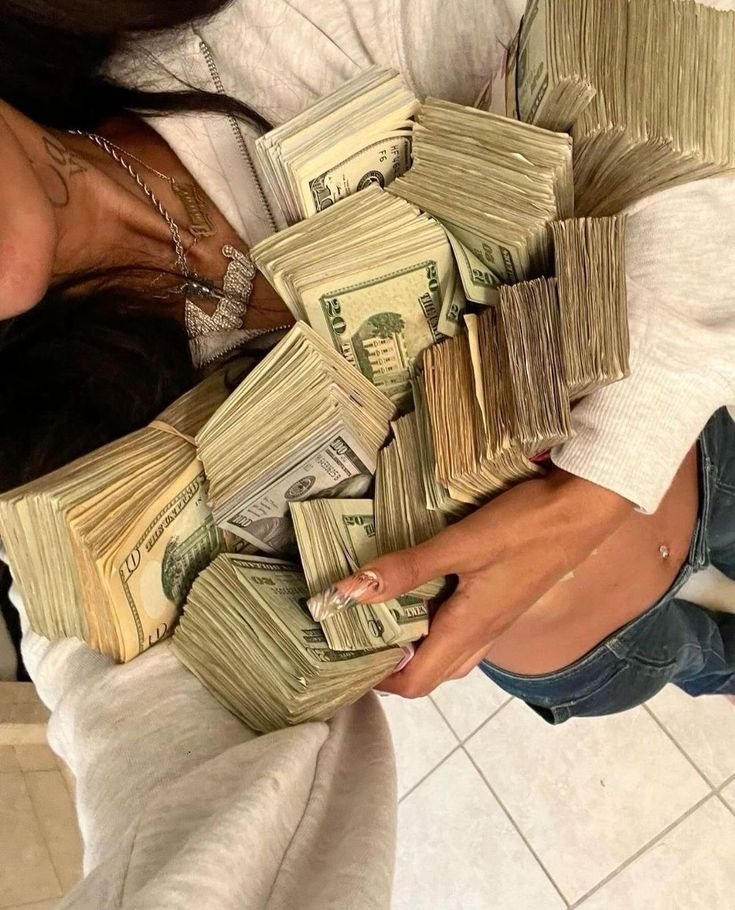 a woman holding stacks of money in her hands