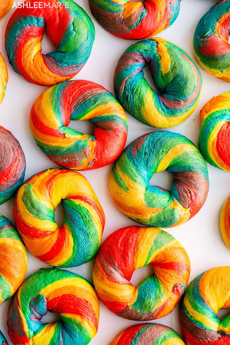 rainbow doughnuts with icing and sprinkles on white table top