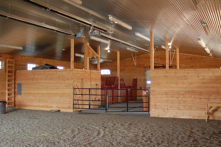 the inside of a horse barn with wooden walls