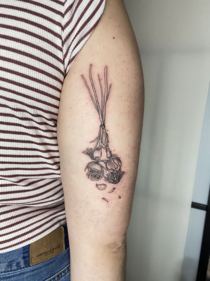 a woman's arm with a tattoo on it that has carrots and onions