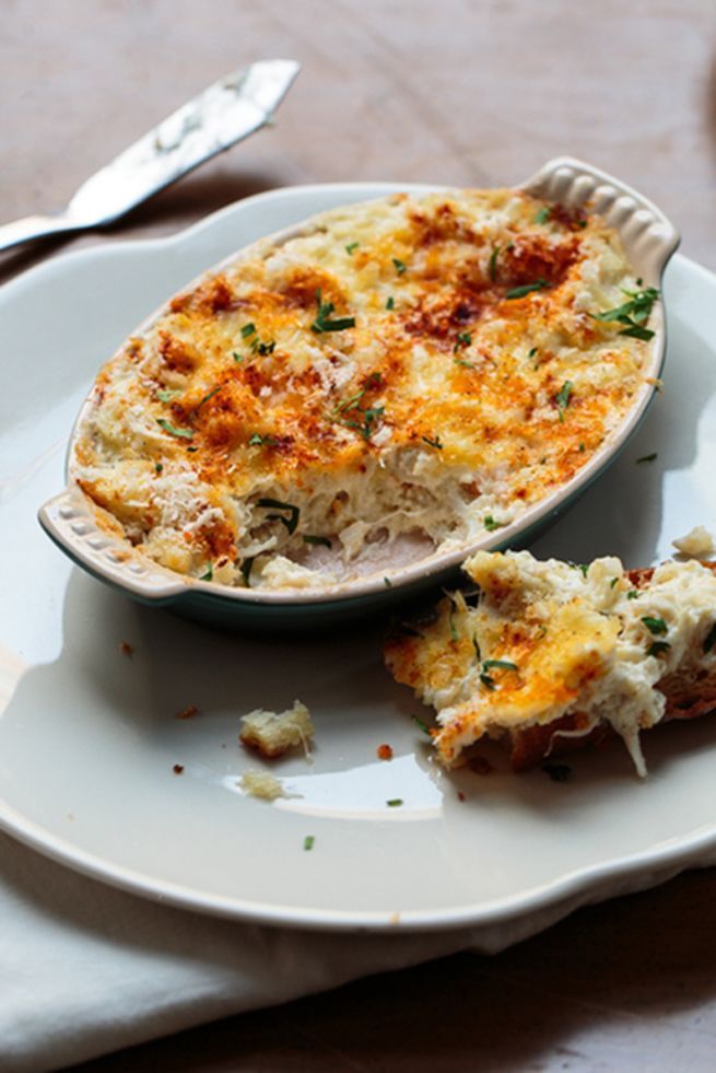 a white plate topped with a casserole covered in cheese