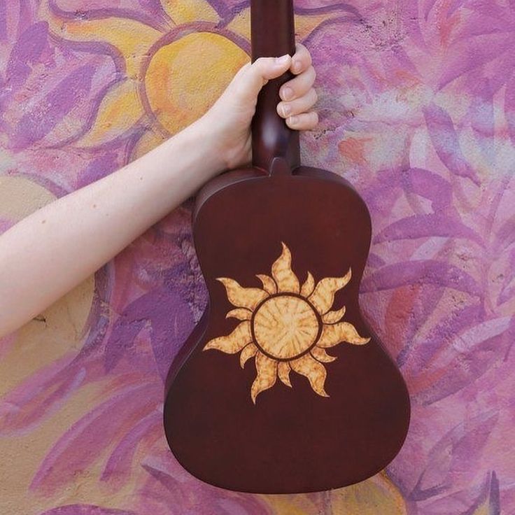 a person's hand holding an acoustic guitar