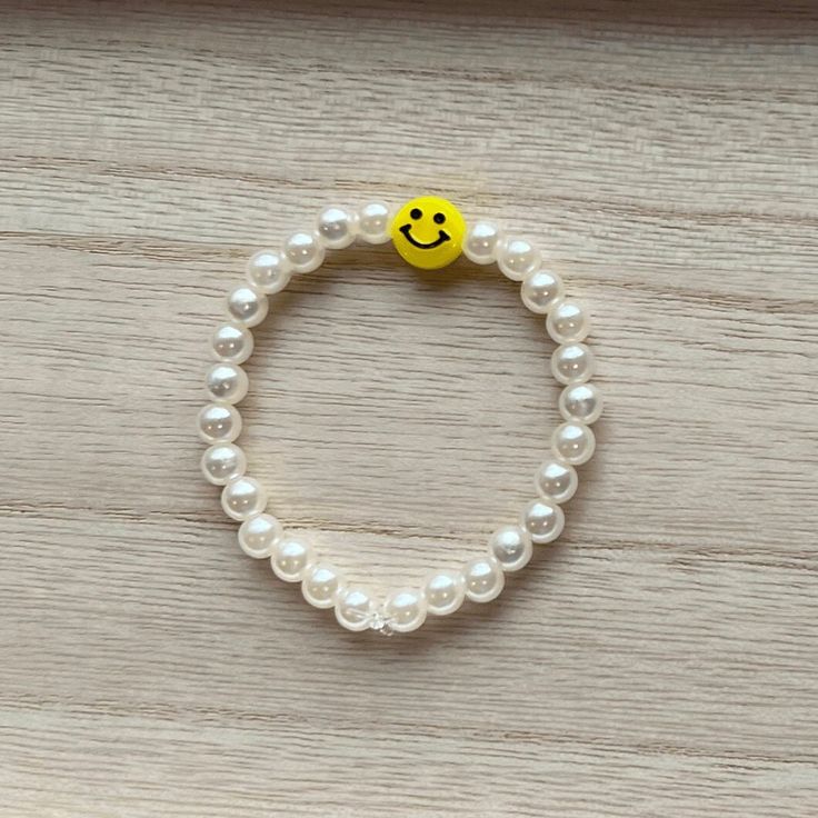 This bracelet is Smiley Pearl! It includes a yellow charm, that is very bright and stylish! The bracelet string used is 5-6 1/2 inches long, this string is stretchy and is able to fit many different wrist sizes! If a different size is needed please add a note to your order. This item is made with pearls and a smiley face charm. The smiley face charm may rub off over time. Trendy Yellow Stretch Bracelet For Everyday, Casual Yellow Beaded Bracelets With Smiley Face, Everyday Yellow Stretch Bracelet With Round Beads, White Hypoallergenic Casual Charm Bracelet, Hypoallergenic White Casual Charm Bracelet, Casual Hypoallergenic White Charm Bracelet, Casual White Hypoallergenic Charm Bracelet, Casual Hypoallergenic Yellow Jewelry, Casual Yellow Hypoallergenic Jewelry