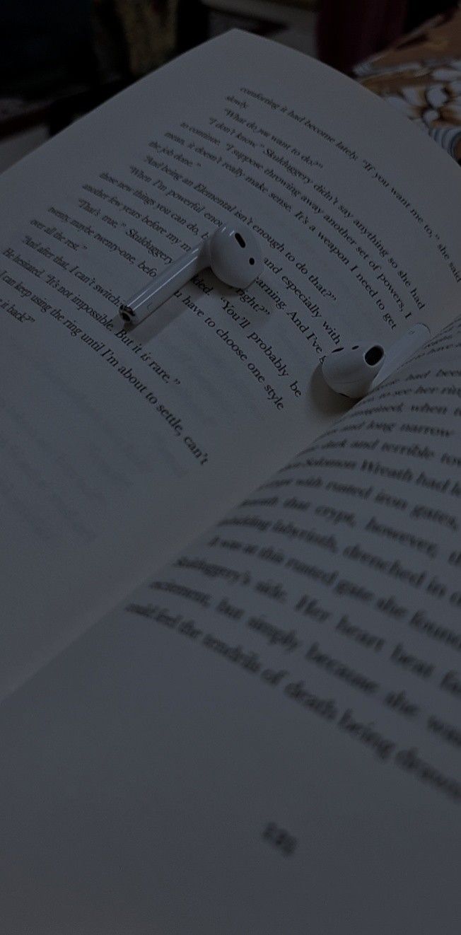 an open book with earbuds laying on it