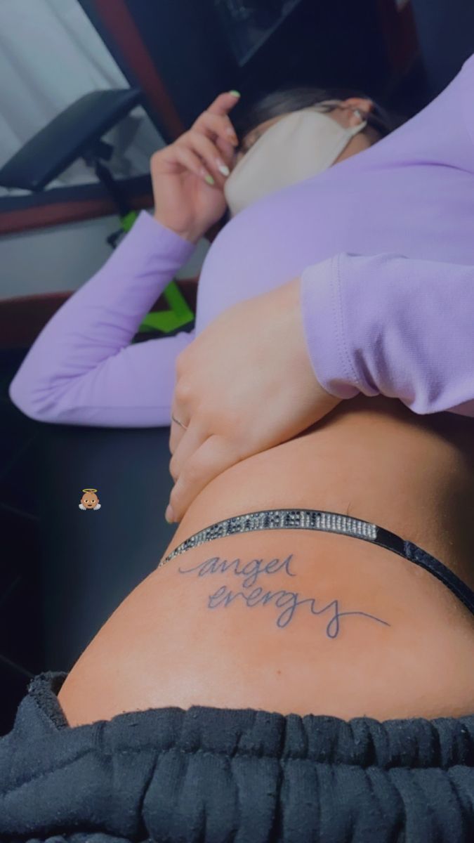 a woman laying in bed with her stomach covered by writing on the side of her body