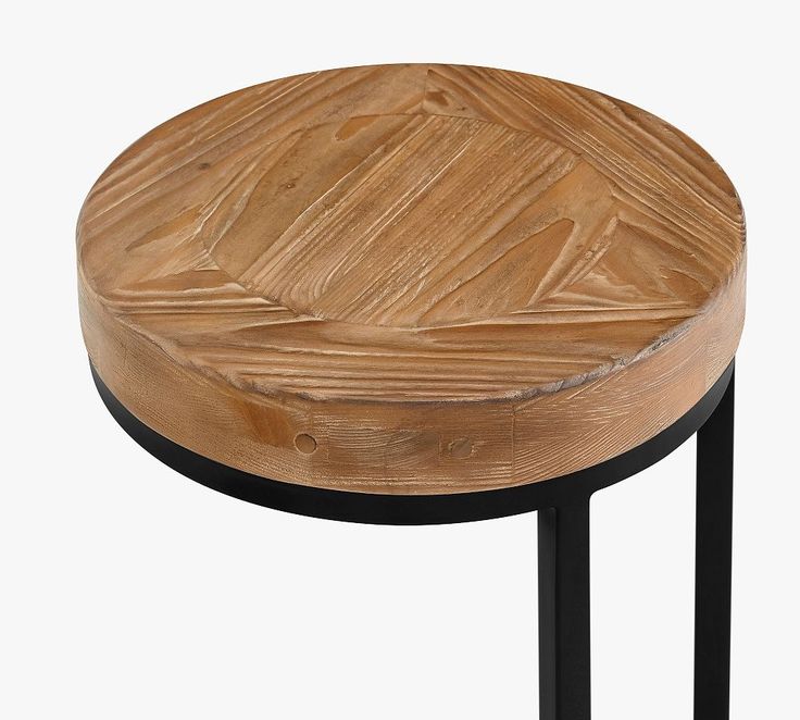 a round wooden table with black metal legs