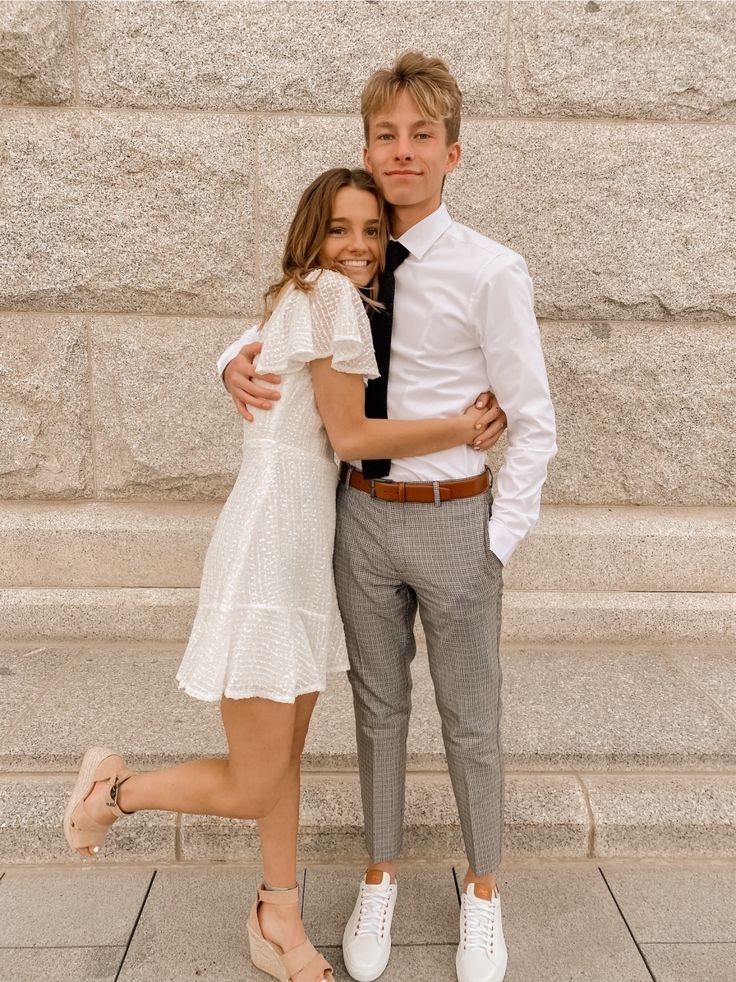 a young man and woman standing next to each other