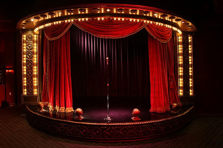 an empty stage with red curtains and lights