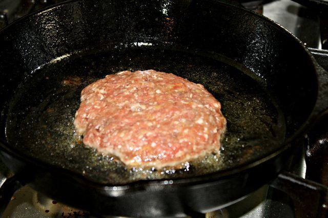 a hamburger is cooking in a skillet on the stove