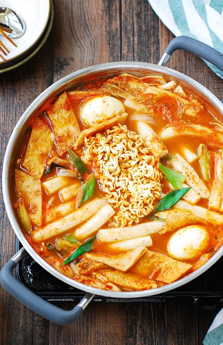 a pot filled with food sitting on top of a wooden table