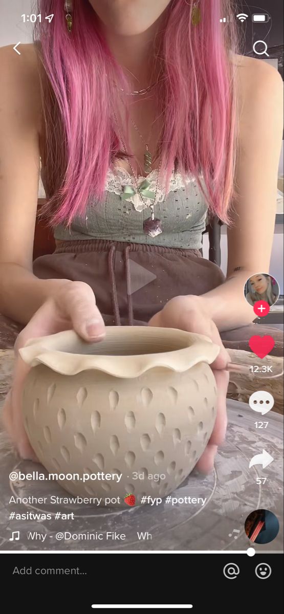 a woman with pink hair is holding a bowl