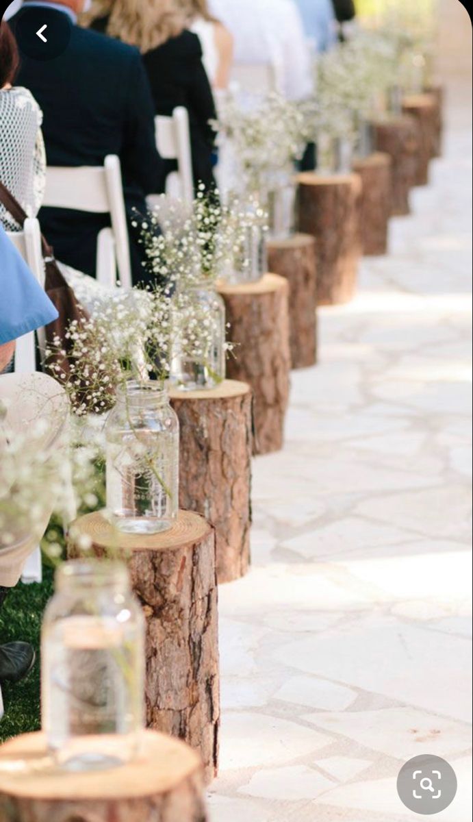 a row of chairs with vases filled with baby's breath flowers