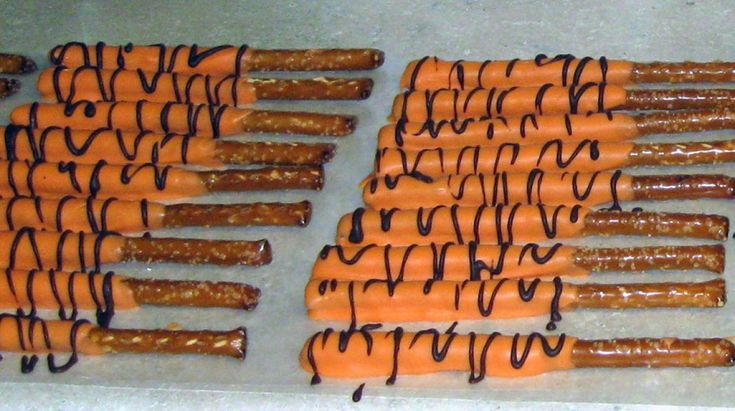 several pretzels with chocolate drizzled on them sitting on a baking sheet