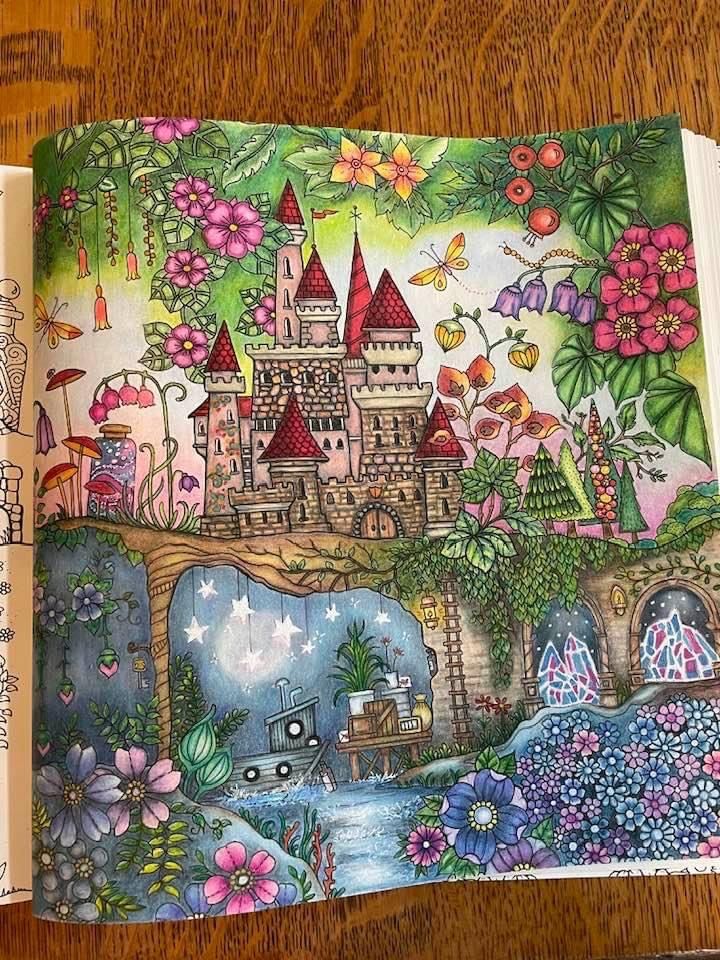 an open children's book on a table with flowers and castle in the background