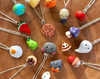 a bunch of different items that are on a wooden table with chain necklaces hanging from it's sides