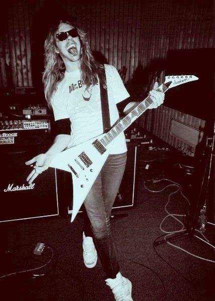 a woman in white shirt playing an electric guitar