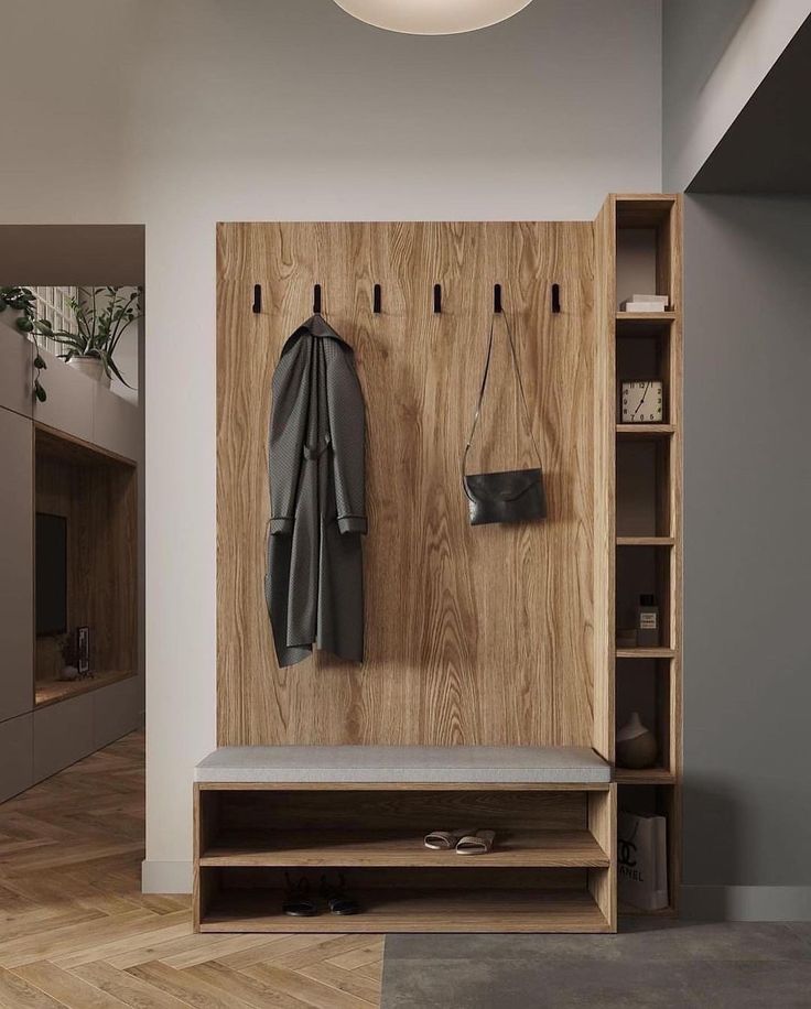 a coat rack with two coats hanging from it's hooks, and a bench in the foreground