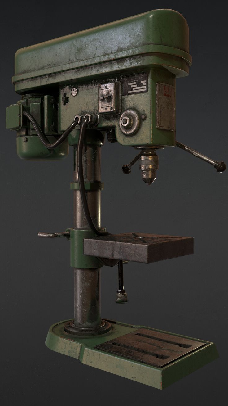 an old green machine sitting on top of a wooden table next to a black background