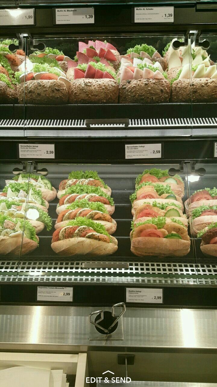 a display case filled with lots of sandwiches and salads on top of glass shelves