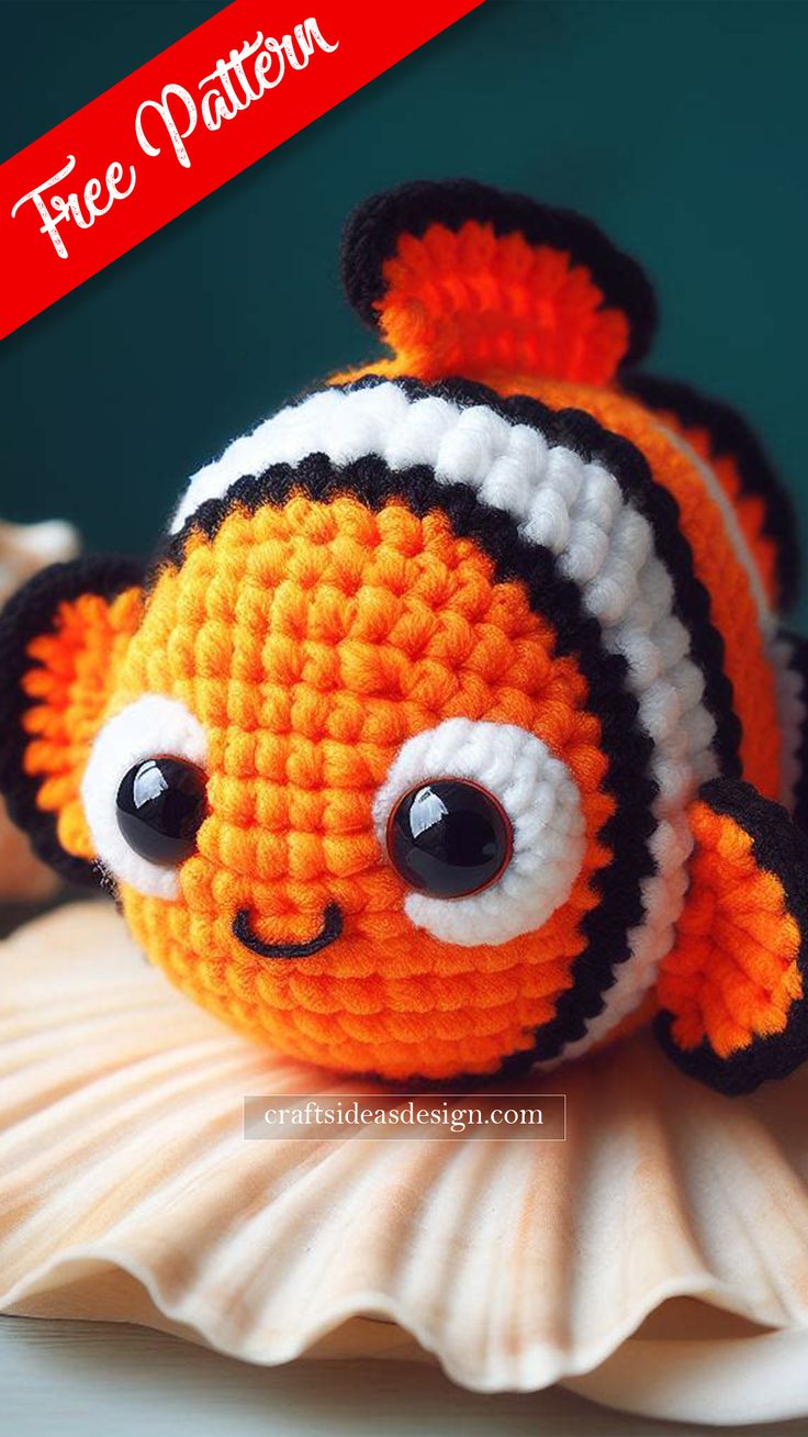 a crocheted clown fish sitting on top of a white shell with the caption free pattern