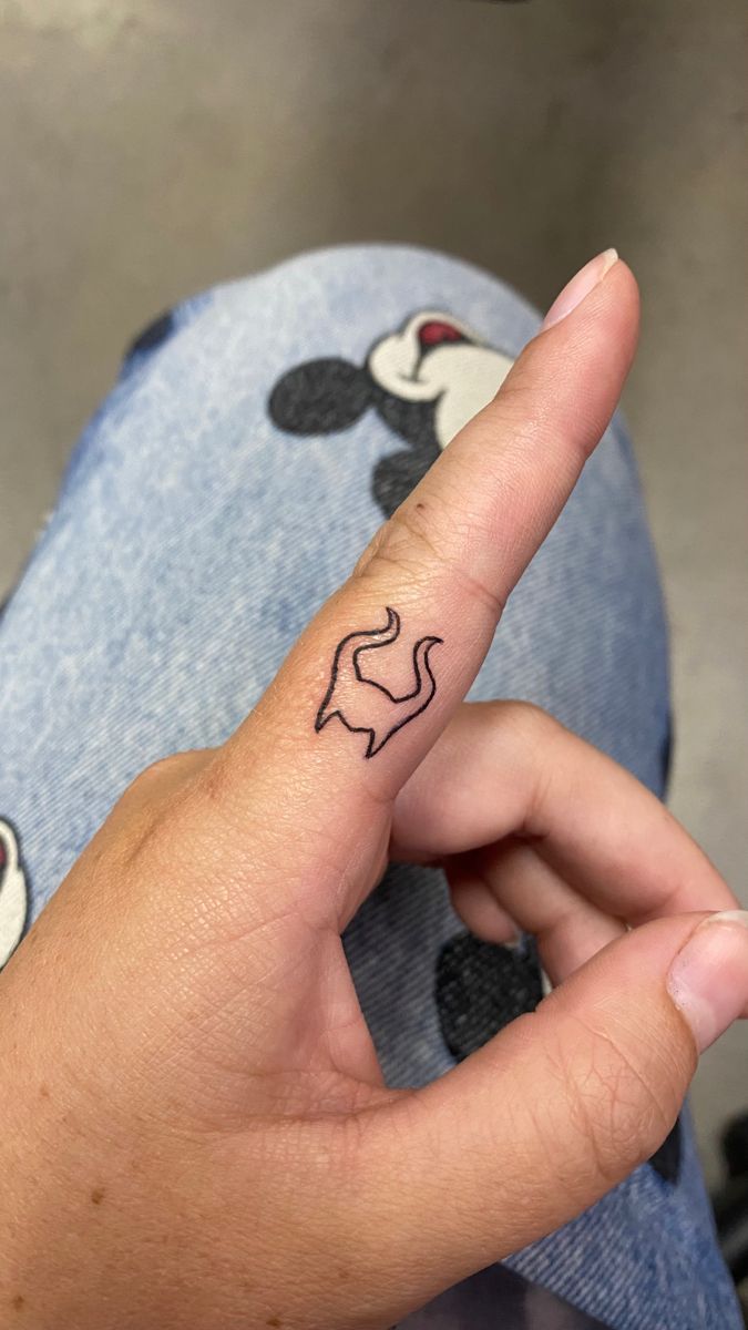 a person's hand with a small tattoo on their finger pointing to the side