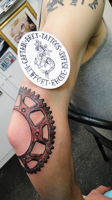 a man with a tattoo on his arm has a bicycle wheel sticker on it