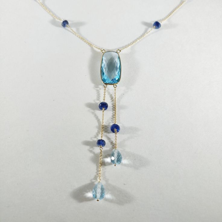 **KINDLY CHECK OUT THE VIDEO OF THE ITEM FOR A CLEARER VIEW**Details of the Necklace: Length of necklace is 16 inches. Other sizes available on request. Gemstone : Sky Blue Topaz Gemstone shape, size and weight- cushion , 20x10mm,10.08 carats Blue sapphire beads-3mm, 9ec,5.55 carats Sky blue topaz drops-7x5mm,3.25 carats, 2 pec Total Gemstone weight: 18.88 carats Metal: GOLD Purity: 14K (58.33%)approx Gold Weight: 1.63 grams Total weight: 5.41 grams Aunthtic sky Blue Topaz cushion, blue sapphire Elegant Blue Tanzanite Gemstones, Blue Topaz Drop Necklaces, Blue Drop Necklaces With Blue Topaz, Blue Aquamarine Drop Jewelry, Blue Gemstones With Accents Fine Jewelry, Faceted Blue 14k Gold Jewelry, Faceted Blue Topaz Blue Necklace, Blue Aquamarine Briolette Necklace, Blue Briolette Necklace For Anniversary