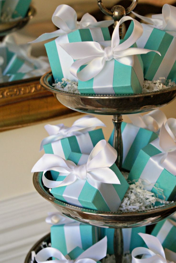 three tiered trays with blue and white gift boxes on top of each other