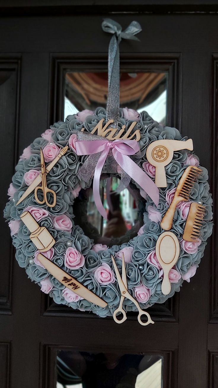 a wreath with scissors, combs and hairdryers hanging on the front door