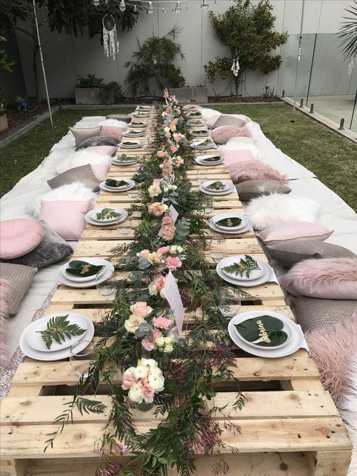 a long table set up with plates and place settings for an outdoor dinner or bridal party