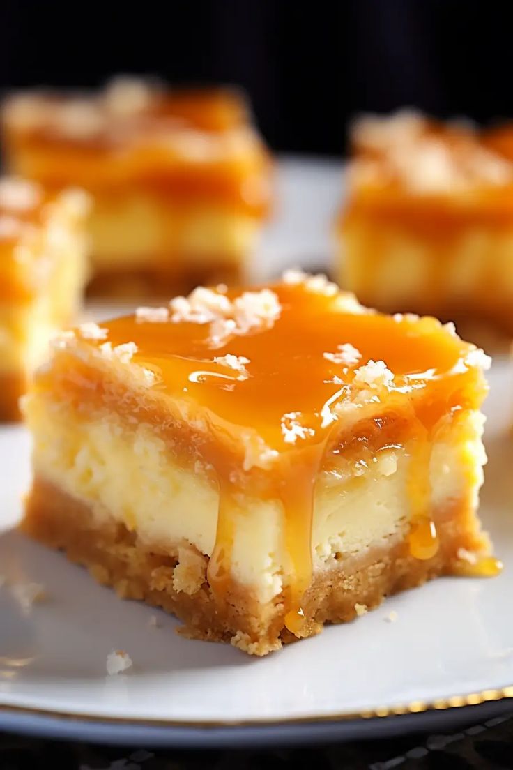 several pieces of cheesecake on a white plate with caramel sauce drizzled over the top