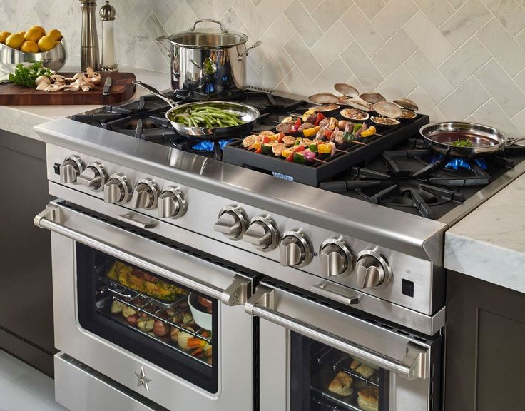 a stove top oven sitting in a kitchen next to a counter with food on it