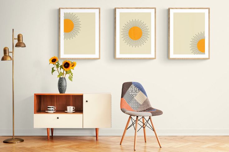 three sunflowers are on the wall next to a small table with a chair