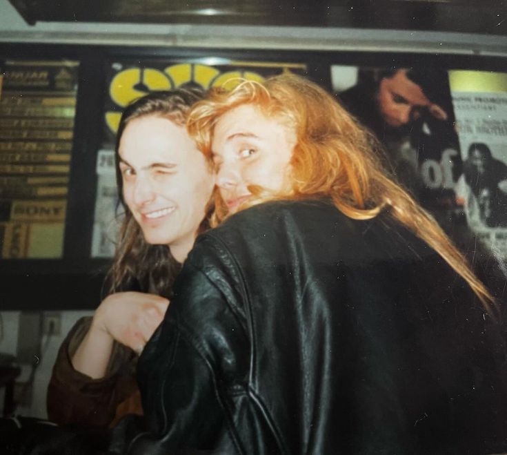 two women standing next to each other at a bar