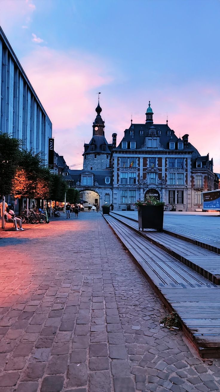 an empty street with benches and buildings in the background