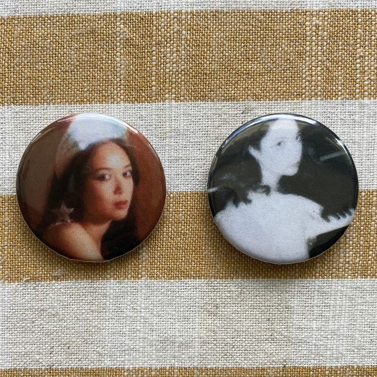 two buttons on a table with a dog and a woman's face in the center