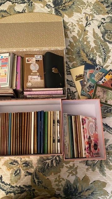 an open box on top of a bed filled with books