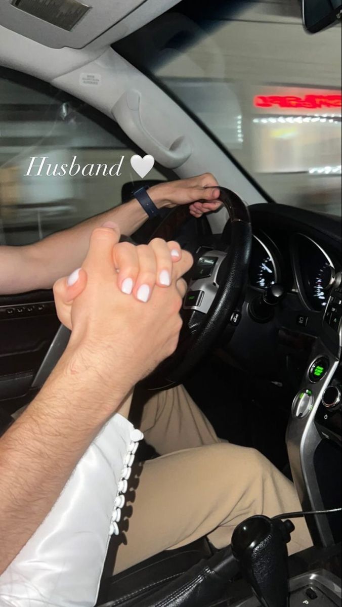 a man driving a car with his hand on the steering wheel