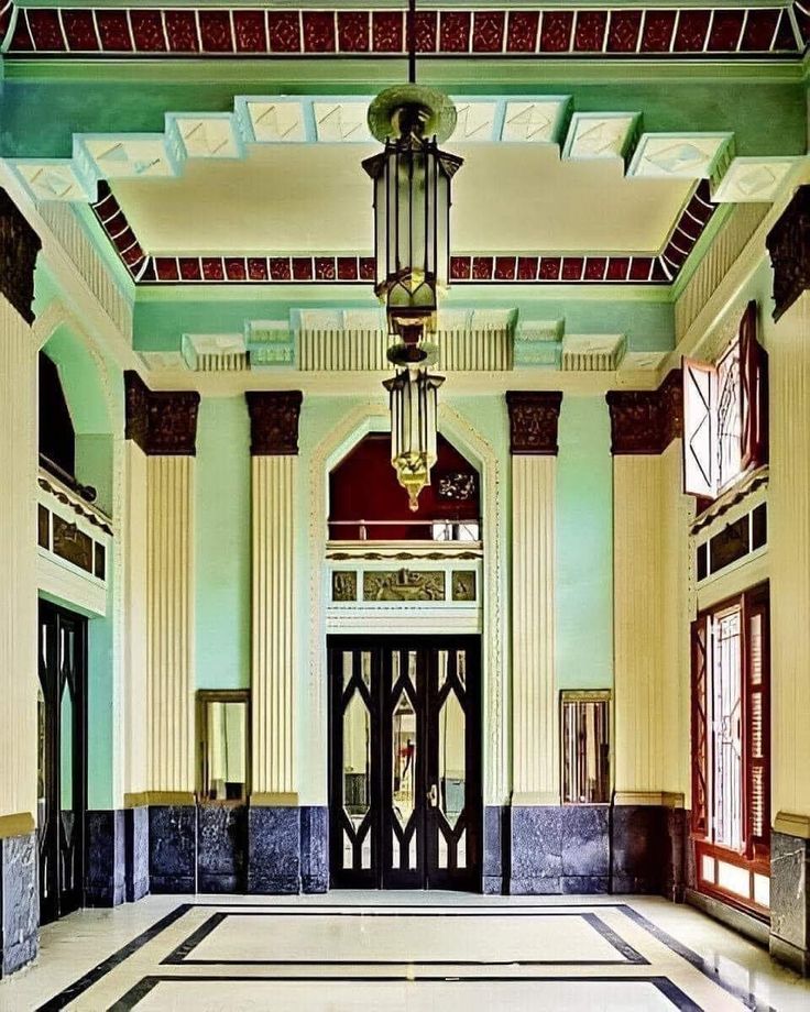 the entrance to an ornate building with columns and windows on either side of the door