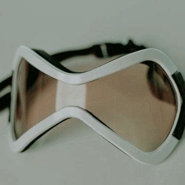 a pair of goggles sitting on top of a white table next to a wall